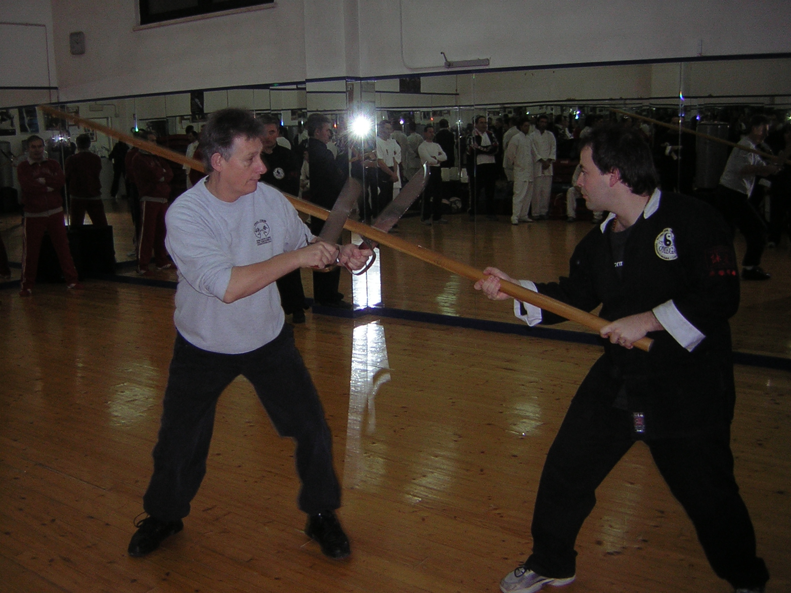Maurizio Petri con Sifu Clive Potter (a sin.) che spiega il un'applicazione del Baat Jaam Dao (Coltelli a farfalla) contro il Luk Dim Boon Gwun (Bastone lungo)